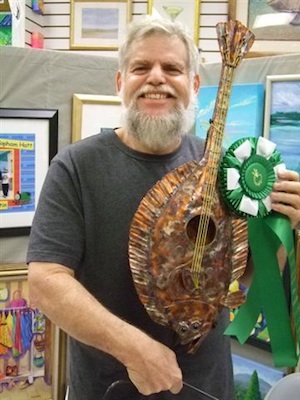 Image 1 - August Powers is best known for the musical instruments he sculpts for the annual Lower Keys Underwater Music Festival, including this fluke-a-lele. 